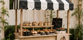 Carrito de snacks con toldo a rayas y pasteles